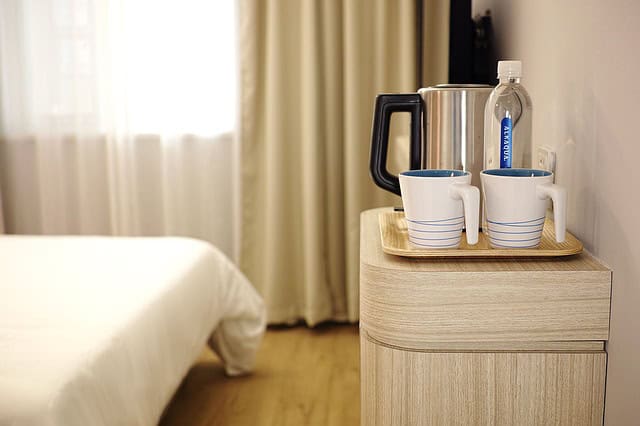 Personal touches like coffee, mugs, and water bottles make hotel rooms feel more welcoming to your guests.