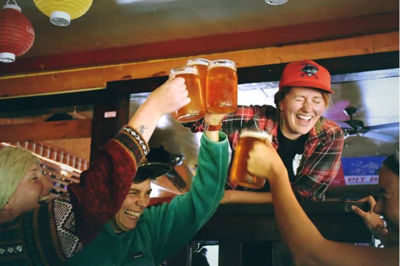 Group of friends cheering with mugs of beer.
