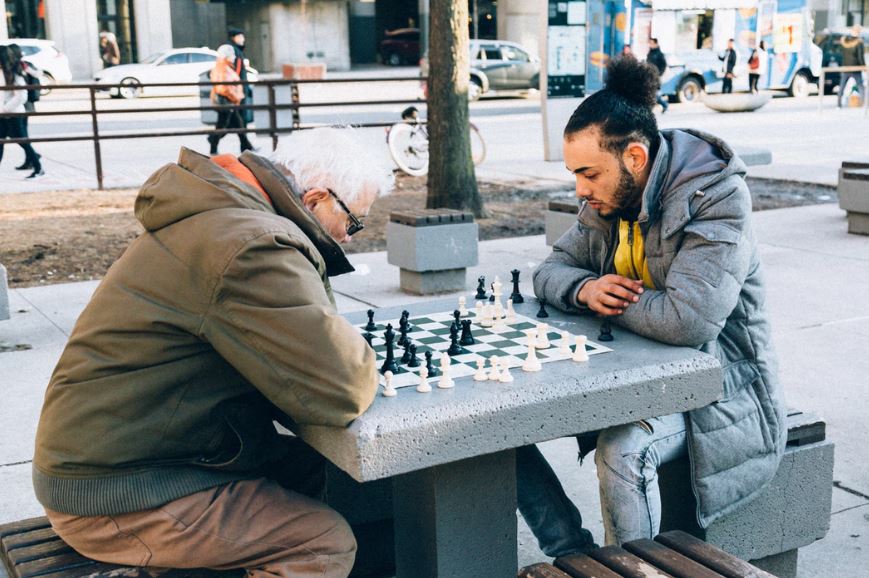 Intergenerational programs bring the senior community together for events like playing chess in the park.