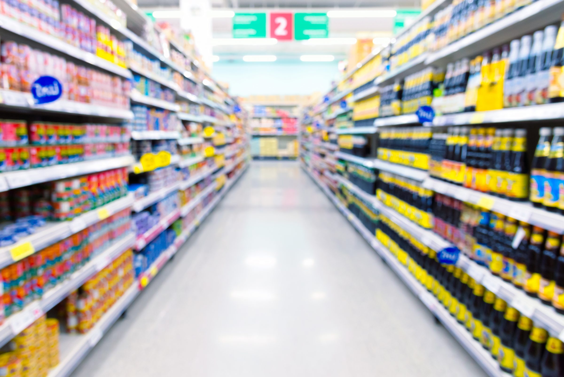 A grocery store aisle is fully stocked with grocery essentials.