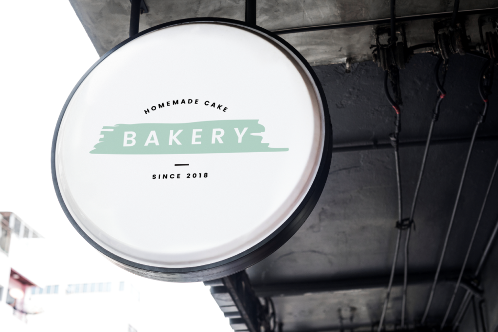 A round outdoor hanging sign says, "Homemade Cake Bakery Since 2018." Keep your bakery's doors open with these smart business tips in a post-pandemic world.