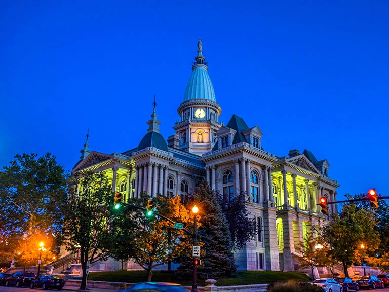 An image of Tippecanoe County Courthouse in Layfyette IN, lit up against a dusk sky.