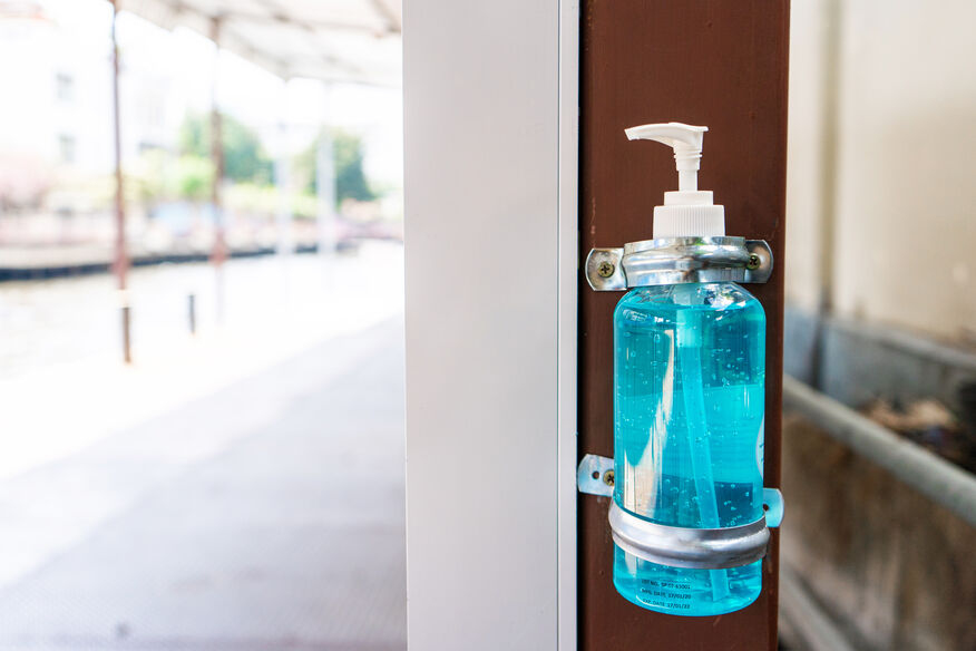 A hand sanitizer bottle is attached to the outside door to help stop the spread of illness in a senior care facility. 